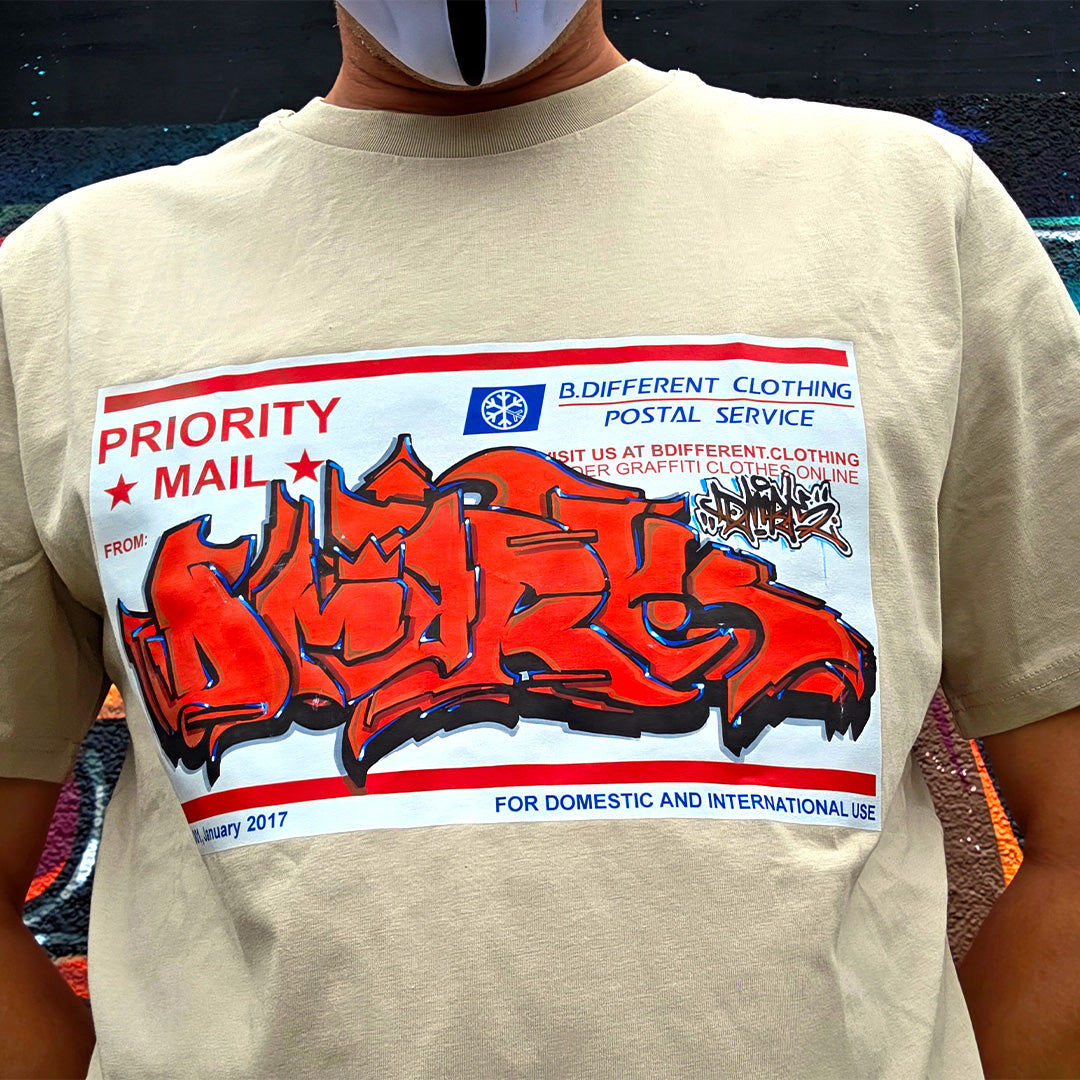 Beige zoom Dmark piece on Priority Mail Sticker Graffiti Tee from B.Different Clothing, graffiti-inspired streetwear t-shirt
